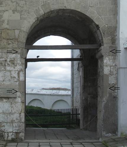 The arch of the Northern passage. Traces of the inherent gate hinges are marked by arrows.